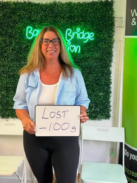 Smiling member at the club showing her results written up on the board