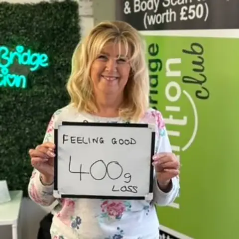 At the Bamber Bridge club, a member holding up the board with her results